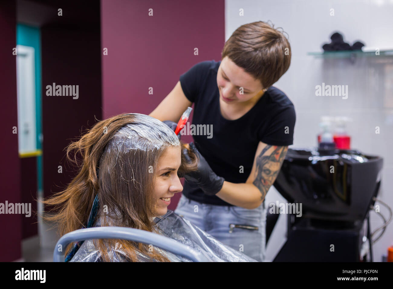 Parrucchiere professionale colorazione dei capelli della donna client presso studio Foto Stock