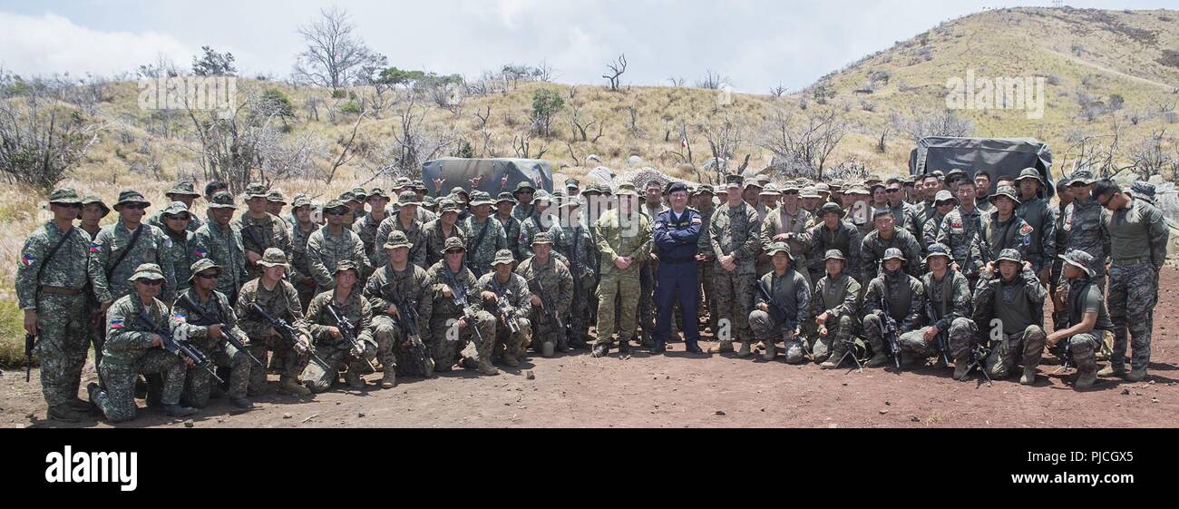 POHAKULOA AREA FORMAZIONE, Hawaii (Luglio 18, 2018) Royal Australian Navy Commodore Ivan Ingham e marina cilena Adm posteriore. Pablo Niemanni, forze combinate di componente navale Commander, centro-destra, pausa per una foto con Marines DA PARTE DEGLI STATI UNITI Marine Corps, cileno Marines, Philippine Marines e Repubblica di Corea Marines durante il cerchio del Pacifico (RIMPAC) esercizio. Venticinque nazioni, 46 navi, cinque sommergibili e circa 200 aerei e 25.000 personale partecipano RIMPAC dal 27 giugno al 2 agosto in e intorno alle Isole Hawaii e la California del Sud. Il più grande del mondo di Ospiti int Foto Stock