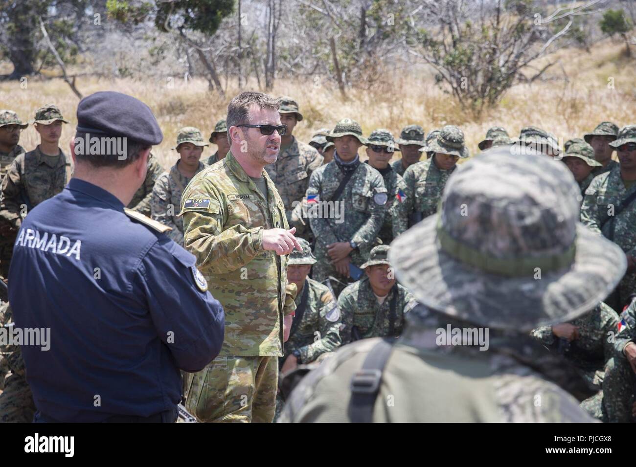 POHAKULOA AREA FORMAZIONE, Hawaii (Luglio 18, 2018) Royal Australian Navy Commodore Ivan Ingham, parla con i membri dell'U.S. Marine Corps, cileno Marines, Philippine Marines e Repubblica di Corea Marines durante il cerchio del Pacifico (RIMPAC) Esercizio, 18 luglio. Venticinque nazioni, 46 navi, cinque sommergibili e circa 200 aerei, e 25.000 personale partecipano RIMPAC dal 27 giugno al 2 agosto in e intorno alle Isole Hawaii e la California del Sud. Il più grande del mondo marittimo internazionale esercitazione RIMPAC offre una singolare opportunità di formazione promuovendo e sostenendo il co Foto Stock