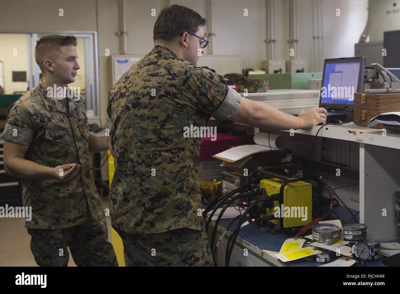 Sgt. Justin W. Ivie, destra e Cpl. Davis E. Steiner, sinistra, calibrare un veicolo automatizzato sistema diagnostico a Camp Kinser, Okinawa, in Giappone il 23 luglio 2018. Per una corretta calibrazione del sistema consente di Marines per identificare correttamente i problemi con i veicoli in tutta la terza Marine Logistics Group. Ivie e Steiner sono misure di test e per apparecchiature di diagnostica con i tecnici di manutenzione elettronica azienda logistica di combattimento del reggimento di 35, 3° MLG. Ivie è un nativo di Oviedo, Florida. Steiner è un nativo di Atlanta, Georgia. Foto Stock
