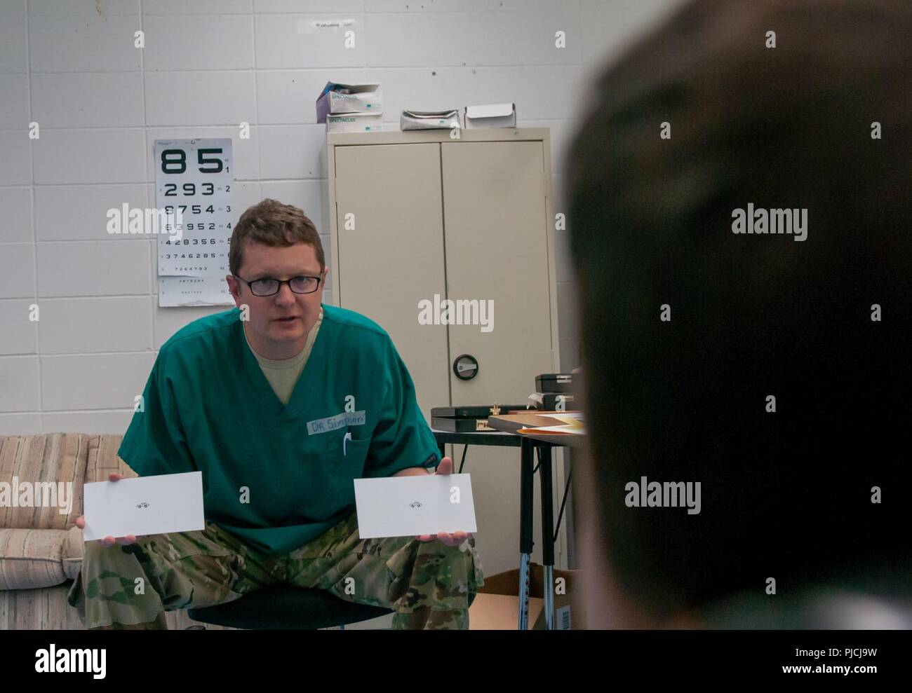 Matthew Simpson, un all'ottico optometrista con il medico 7218th Unità di supporto, fuori di Louisville, Kentucky, diventa un noioso visita ai medici in una divertente esperienza per 4-year-old Jonathan Howard, un residente locale, il 17 luglio 2018. Simpson sta partecipando a un dipartimento della difesa prontezza innovativa missione di formazione che costruisce la preparazione militare portando assistenza medica di qualità in membri della balumina Lago Prenotazione indiana e comunità circostante al bug-O-Nay-Ge-Shig Scuola in Bena, Minnesota. Foto Stock