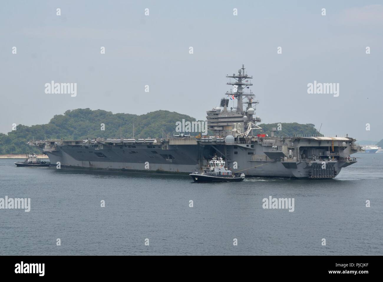 YOKOSUKA, Giappone - STATI UNITI La marina è distribuita portaerei USS Ronald Reagan (CVN 76) restituisce a U.S. Le attività della flotta (FLEACT) Yokosuka. FLEACT Yokosuka fornisce, mantiene e gestisce servizi di base e servizi a sostegno del settimo della flotta di inoltro distribuito le forze navali, 71 comandi di tenant, e 27.000 militari e civili. Foto Stock