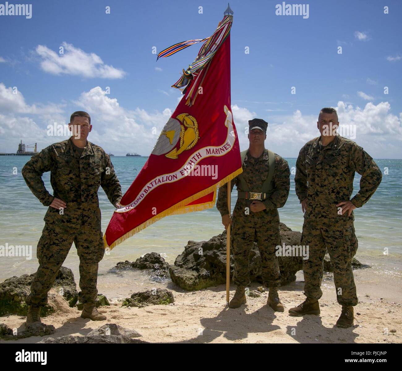 Lt. Col. Daniel Gaskell, Sgt. Il Mag. Daniel Headrick e Sgt. Aaron Mota, stand con i loro colori unità sulla spiaggia rossa 3 in Betio, Kiribati, luglio 22, 2018. In ricordo di uomini in 2° Battaglione, 8° Reggimento Marine che hanno combattuto durante la Battaglia di Tarawa, Marines e marinai restituiti i loro colori per onorare i loro predecessori. 2/8 è distribuito alla terza divisione Marine a Okinawa, in Giappone, come parte della distribuzione di unità di programma. Foto Stock