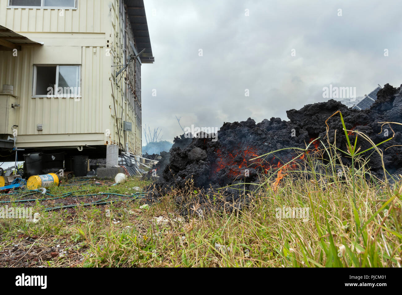 Lava dal vulcano Kilauea, e che emana da una fessura in Leilani Estates, vicino Pahoa, Puna, Hawaii (la Grande Isola), si avvicina a una casa, Hawaii, USA Foto Stock