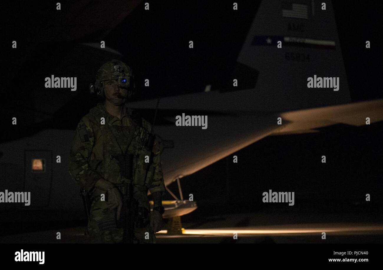 Un U.S. Air Force vola lontano dal team della sicurezza (FAST) membro dal 455th Expeditionary forze di sicurezza Squadron, fornisce la sicurezza di una C-130J Super Hercules assegnato alla 455th Airlift Expeditionary Squadron a Bagram Airfield, Afghanistan, durante la fase di scarico del veicolo le attrezzature e le forniture a Camp Bastion, provincia di Helmand, Afghanistan, 13 luglio 2018. I team veloce volare su specifiche missioni in varie ubicazioni distribuite per garantire la sicurezza e la sicurezza del velivolo e dei suoi membri. Foto Stock