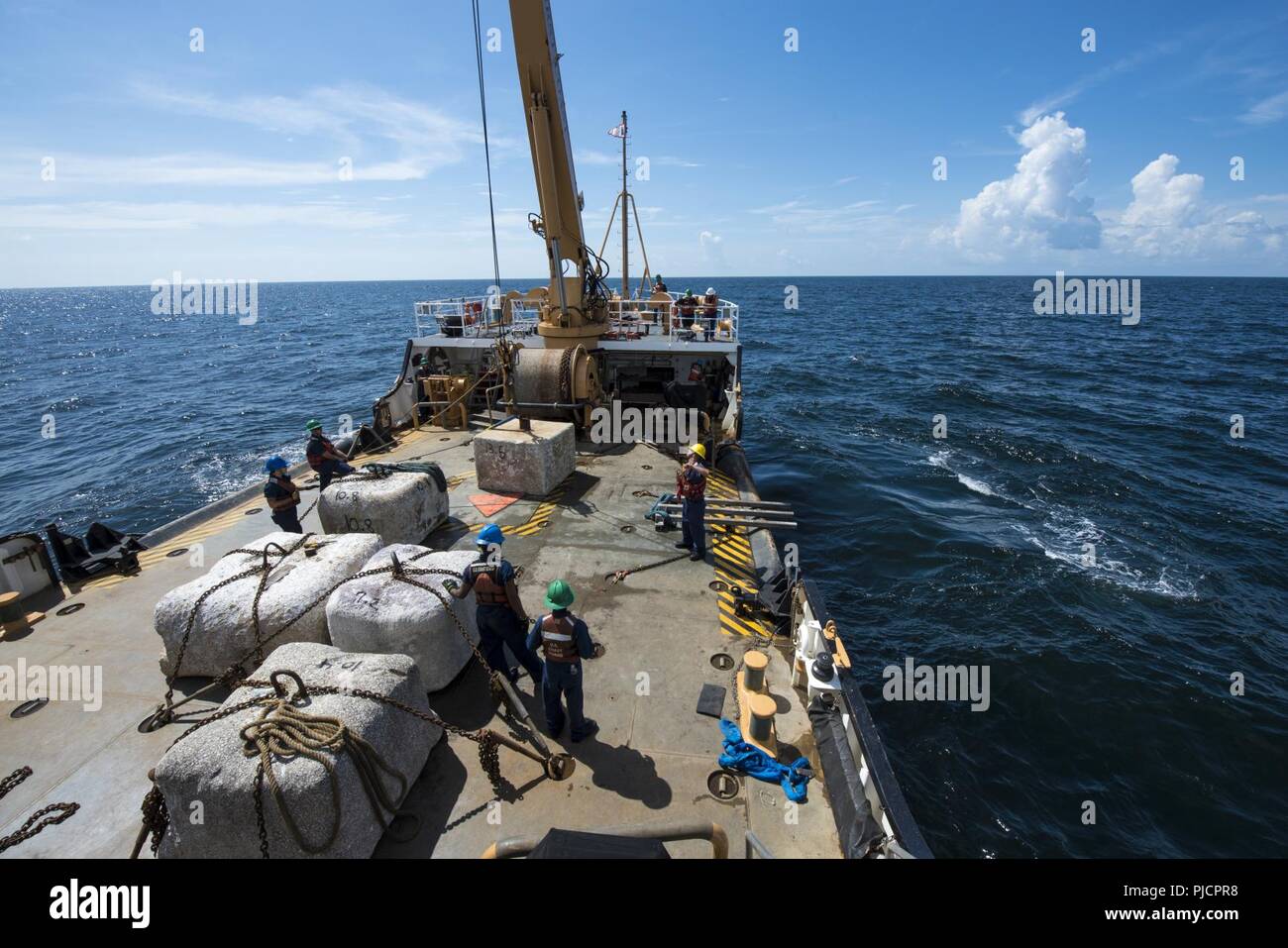 Guardacoste Maria Bray membri di equipaggio preparare per distribuire un vecchio ancora di navigazione, 18 luglio 2018, al largo della costa della Florida nord-est. La Maria Bray equipaggio assistita nella distribuzione di reef palle, costruito da Mandarin gli studenti delle scuole superiori e vecchie ancore di navigazione per pensare che, lavello, Reef, o TISIRI al fine di creare una scogliera sottomarina habitat. Foto Stock