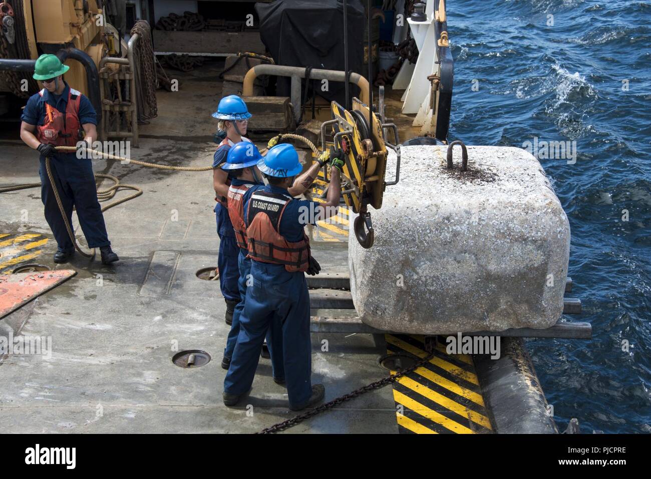 Guardacoste Maria Bray membri di equipaggio preparare per distribuire un vecchio ancora di navigazione, 18 luglio 2018, al largo della costa della Florida nord-est. La Maria Bray equipaggio assistita nella distribuzione di reef palle, costruito da Mandarin gli studenti delle scuole superiori e vecchie ancore di navigazione per pensare che, lavello, Reef, o TISIRI al fine di creare una scogliera sottomarina habitat. Foto Stock