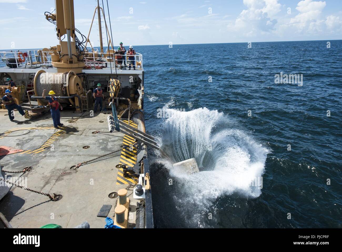 Guardacoste Maria Bray membri di equipaggio distribuire un vecchio ancora di navigazione, 18 luglio 2018, al largo della costa della Florida nord-est. La Maria Bray equipaggio assistita nella distribuzione di reef palle, costruito da Mandarin gli studenti delle scuole superiori e vecchie ancore di navigazione per pensare che, lavello, Reef, o TISIRI al fine di creare una scogliera sottomarina habitat. Foto Stock