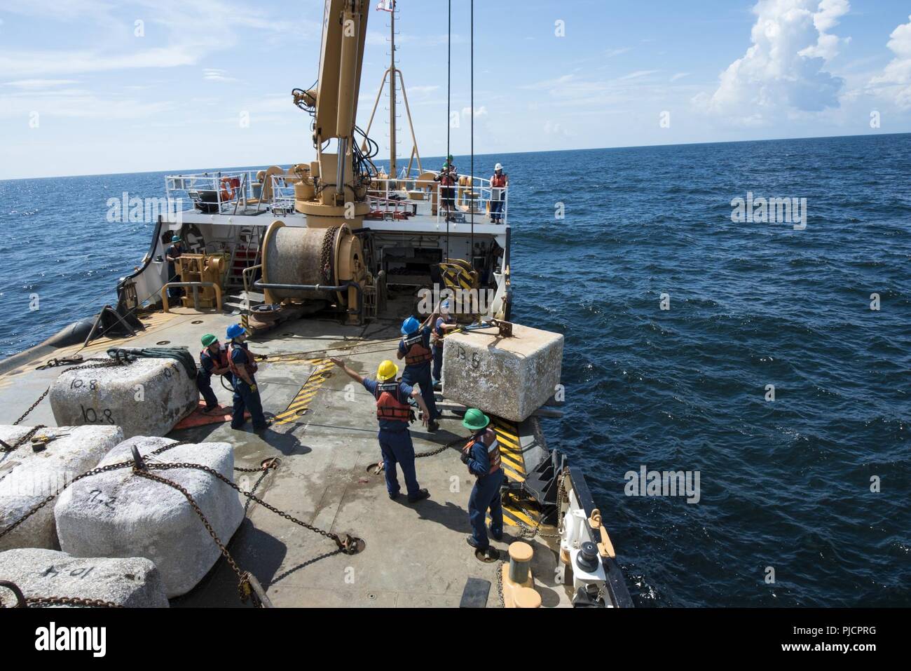 Guardacoste Maria Bray membri di equipaggio preparare per distribuire un vecchio ancora di navigazione, 18 luglio 2018, al largo della costa della Florida nord-est. La Maria Bray equipaggio assistita nella distribuzione di reef palle, costruito da Mandarin gli studenti delle scuole superiori e vecchie ancore di navigazione per pensare che, lavello, Reef, o TISIRI al fine di creare una scogliera sottomarina habitat. Foto Stock