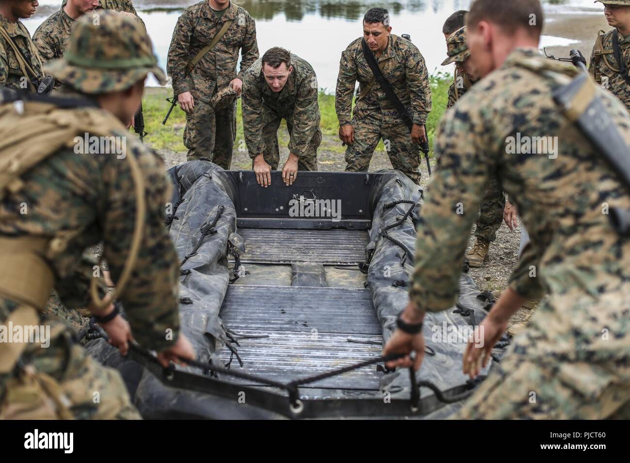 Stati Uniti Marine Cpl. Braxton Shrader, un ingegnere di combattimento con ponte Company, 7 Supporto tecnico di battaglione, Marittima 1 Logistics Group, mostra Marines con 6 ESB, 4 MLG, come disimballare e costruire una lotta contro la razzia di gomma artigianato per essere usato come una barca di sicurezza a Fort Chaffee, arca. Luglio 16, 2018. Durante il fiume Assault 2018, Marines dal sesto e settimo ESB ha avuto la possibilità di condividere esperienze e conoscenze da lavorare mano nella mano conducendo operazioni di rafting sul fiume Arkansas. Foto Stock