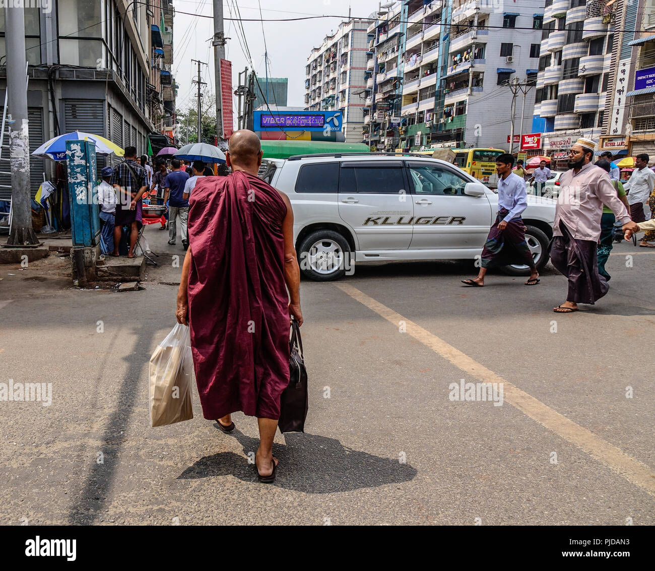 Yangon, Myanmar - Feb 26, 2016. Un monaco camminando sulla strada di Yangon, Myanmar. Per molti anni, le moto sono state vietate in Yangon. Foto Stock