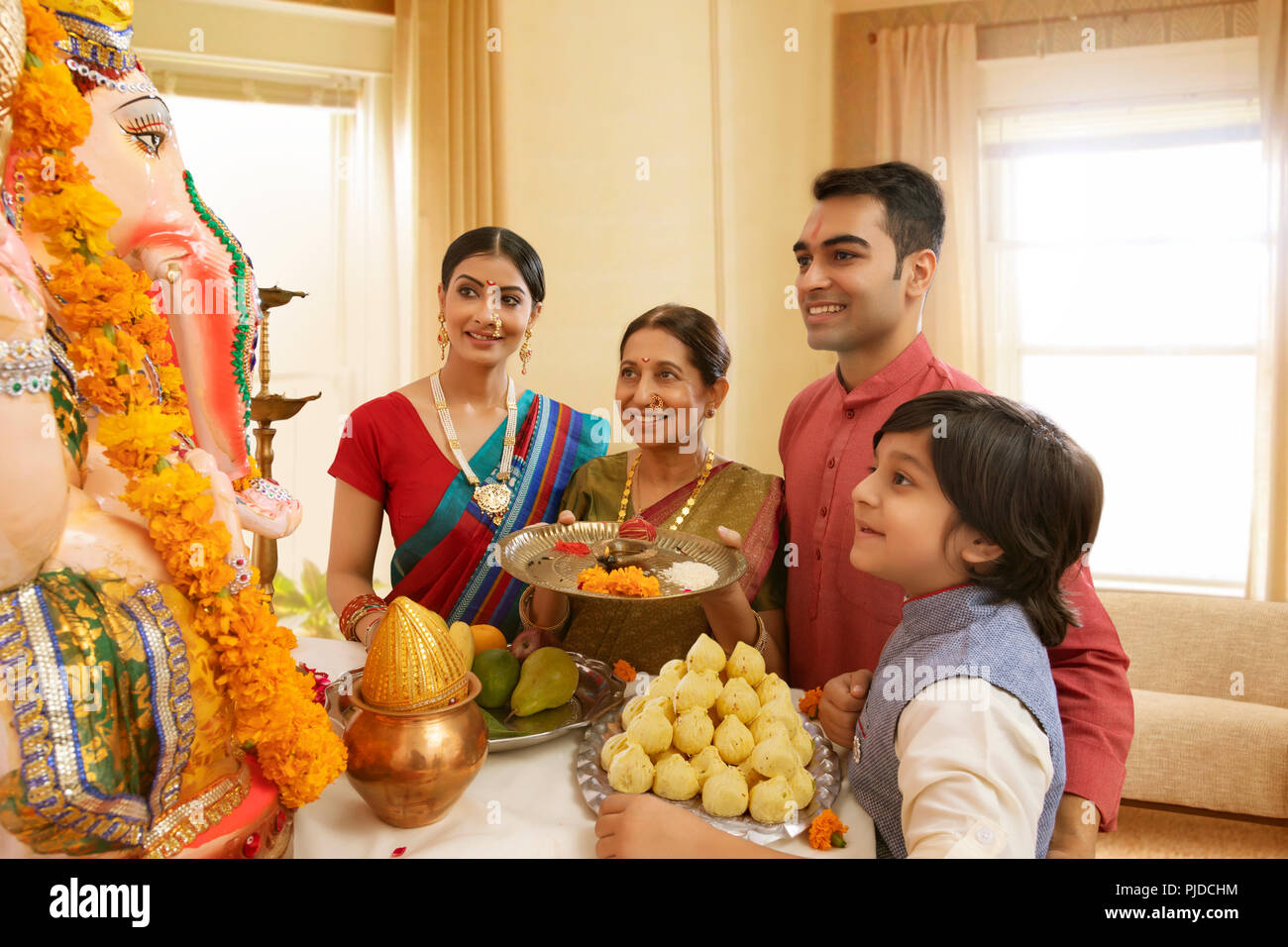 Famiglia Ganpati perfoming aarti sul Ganesh Chaturthi a casa Foto Stock