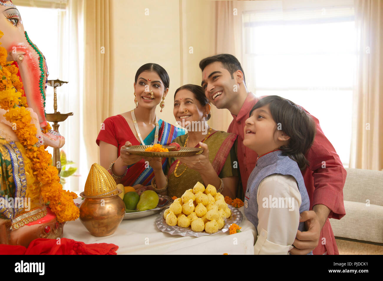 Famiglia Ganpati perfoming aarti sul Ganesh Chaturthi a casa Foto Stock