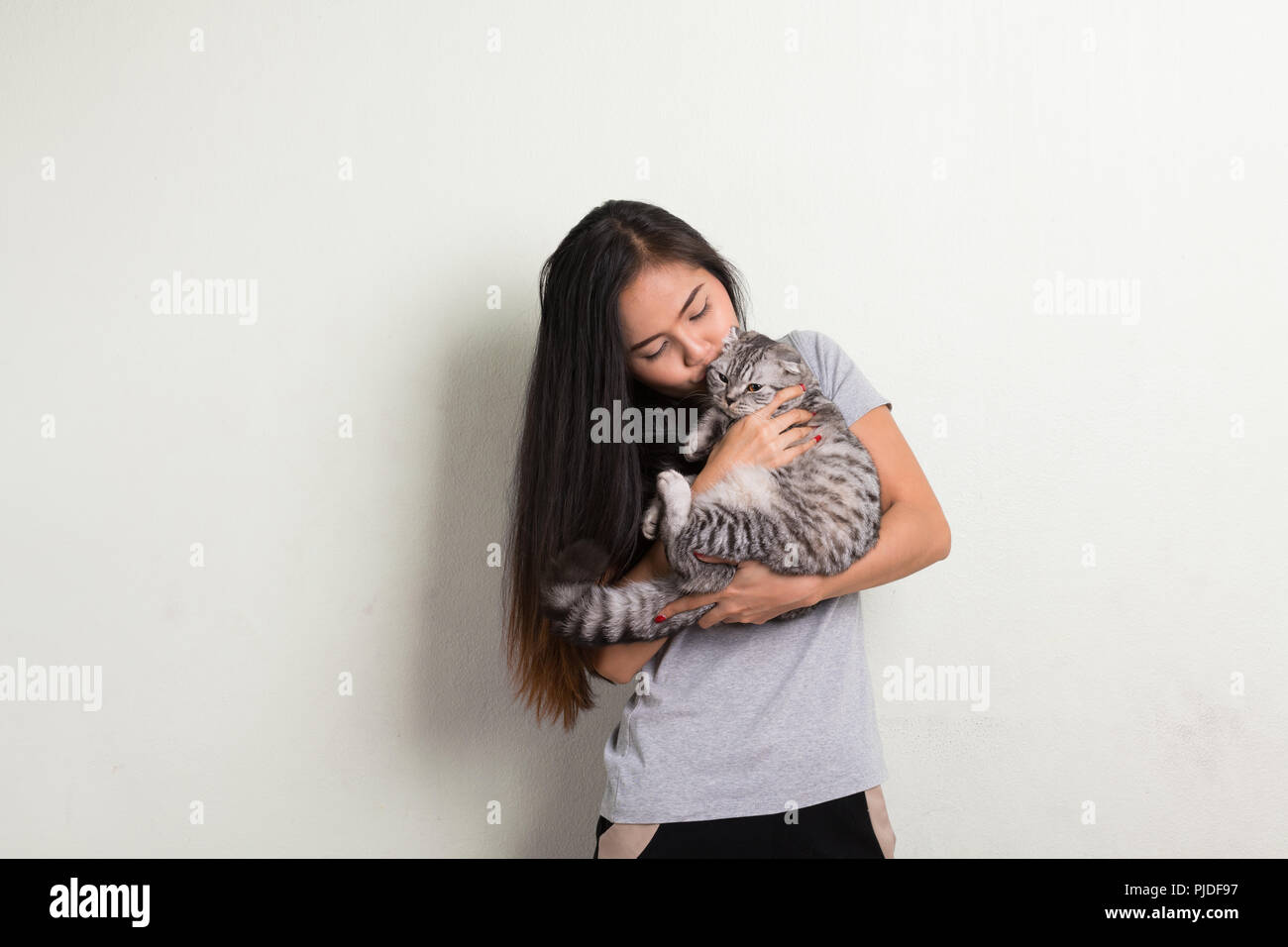 Giovani felici bella donna asiatica kissing cute cat Foto Stock