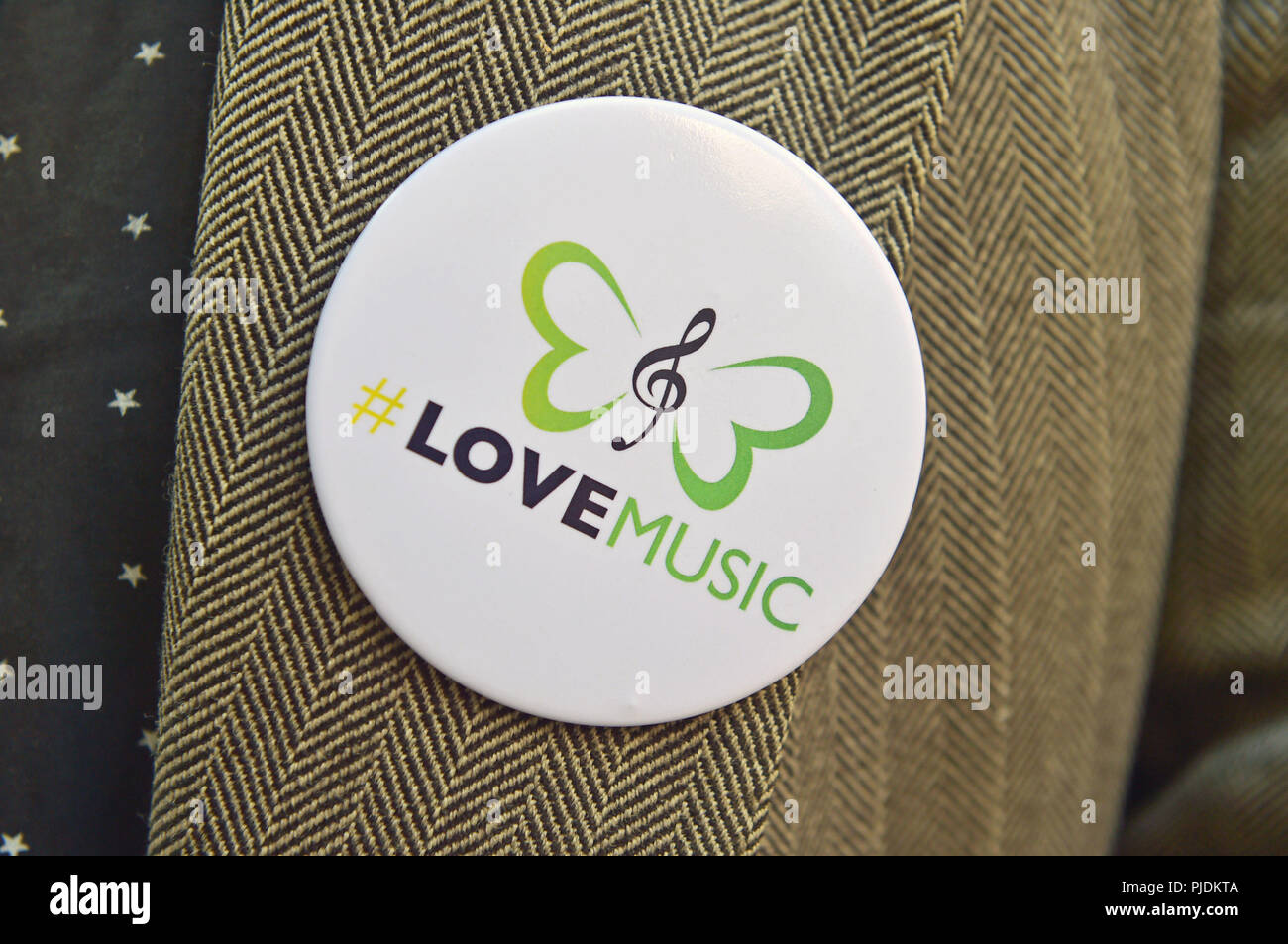 Un badge della campagna di LoveMusic indossato da un protestore fuori da Google a King's Cross, Londra, dove busker e artisti si sono Uniti per protestare contro i giganti della tecnologia "parassiti" in una lotta per una migliore remunerazione. Foto Stock