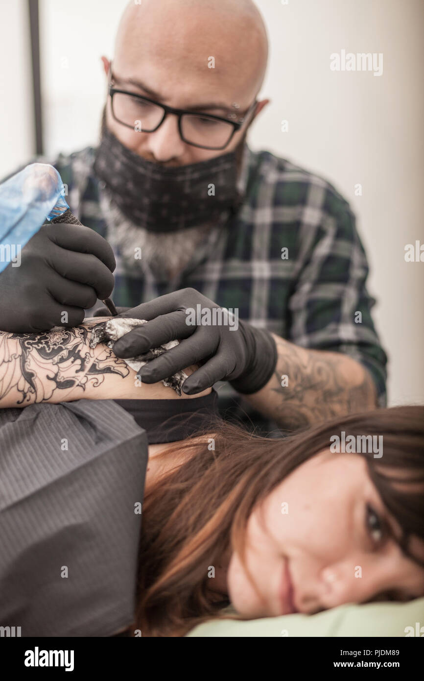 Tattooist disegno sul braccio del client Foto Stock