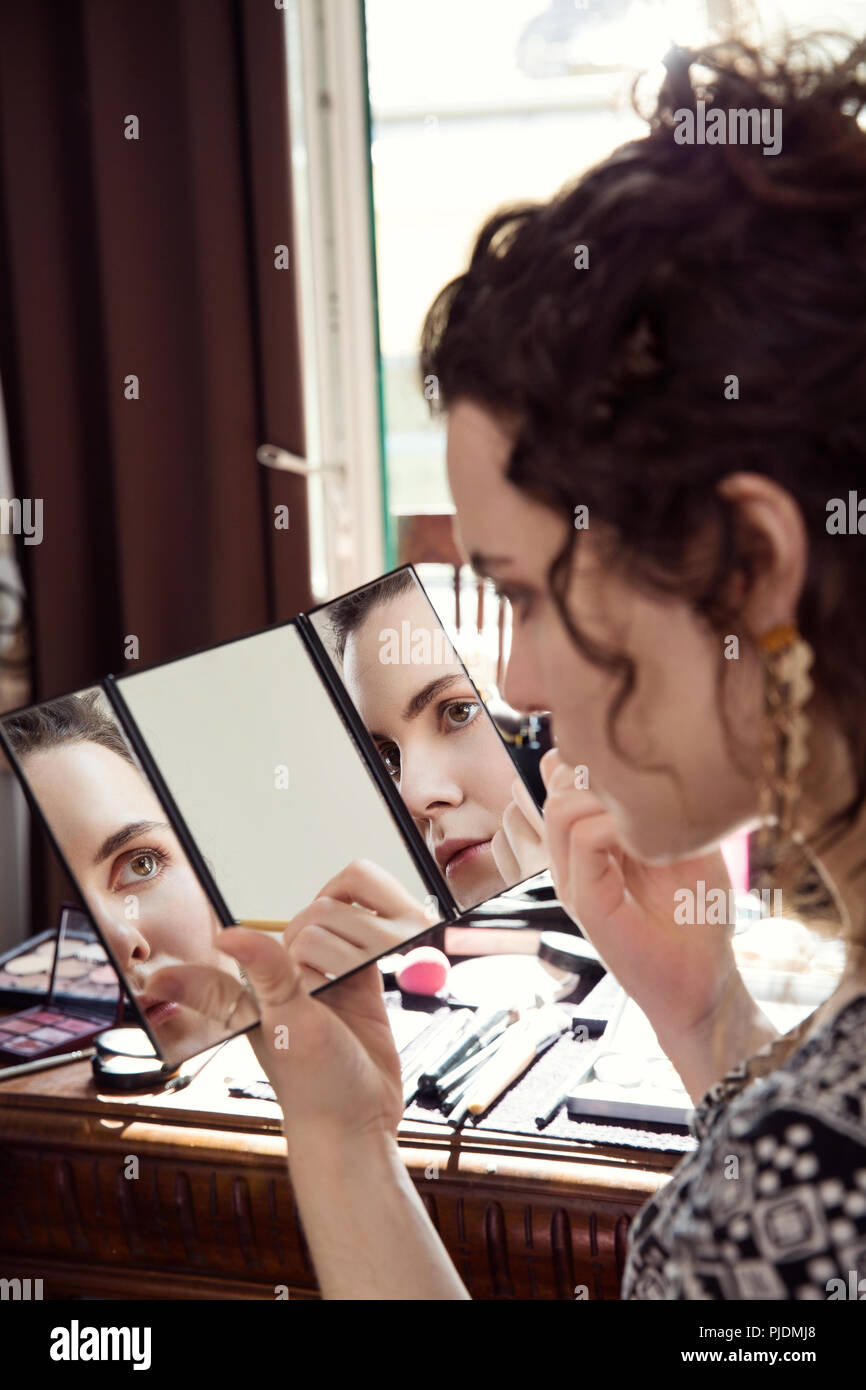 Giovane donna di applicare il make up in camera da letto Foto Stock
