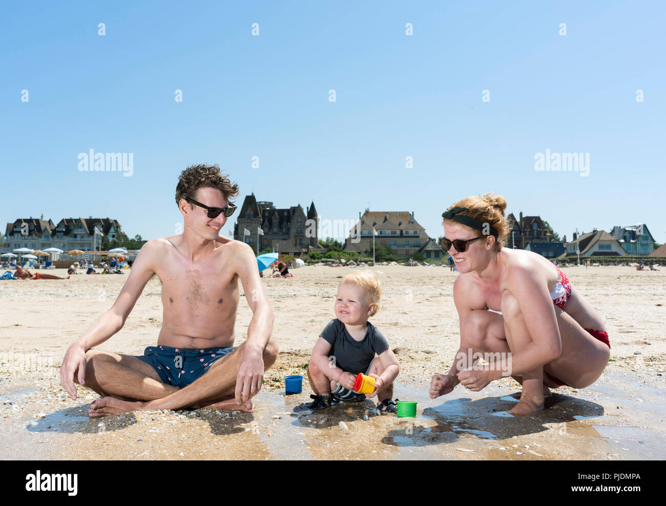 I genitori a giocare con il bimbo sulla spiaggia Foto Stock