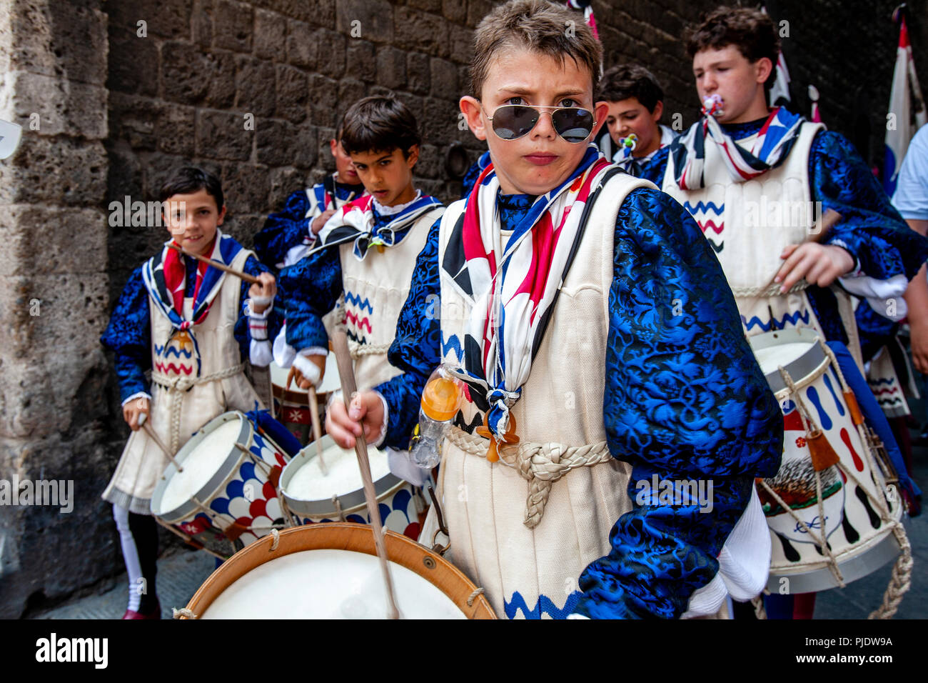 I membri del vincente Istrice (Porcupine) Contrada prendere parte in una rumorosa processione per le strade di Siena, il Palio di Siena, Siena, Italia Foto Stock