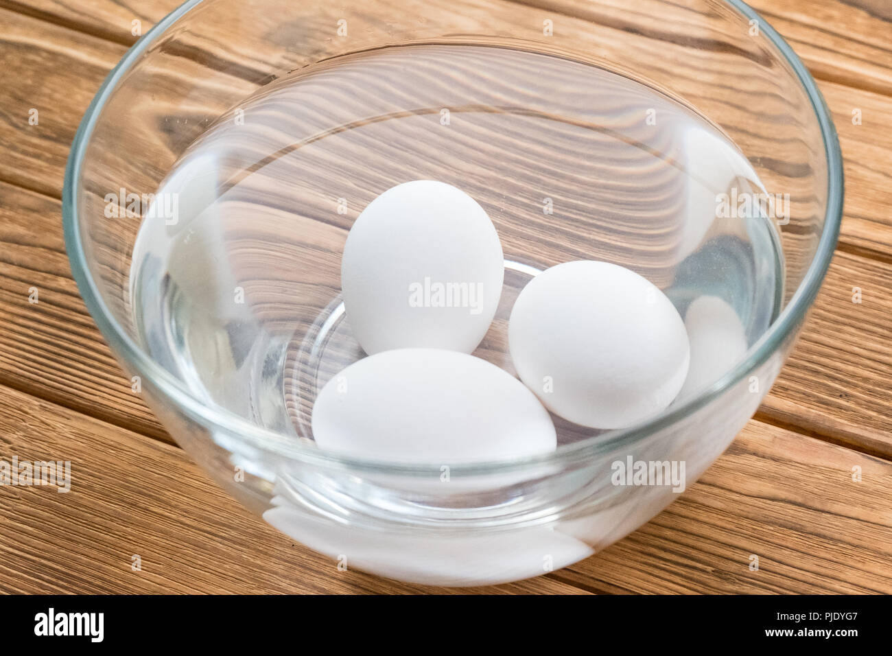 Tre uova di pollo in una ciotola d'acqua. Controllo Freschezza Foto Stock