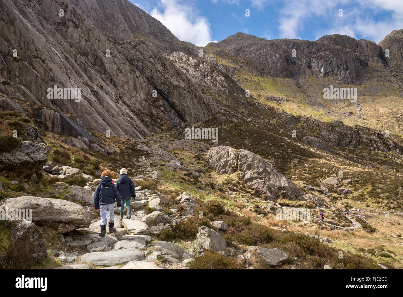 Due bambini piccoli sul sentiero roccioso a Cwm Idwal riserva naturale, Snowdonia National Park, il Galles del Nord. Foto Stock