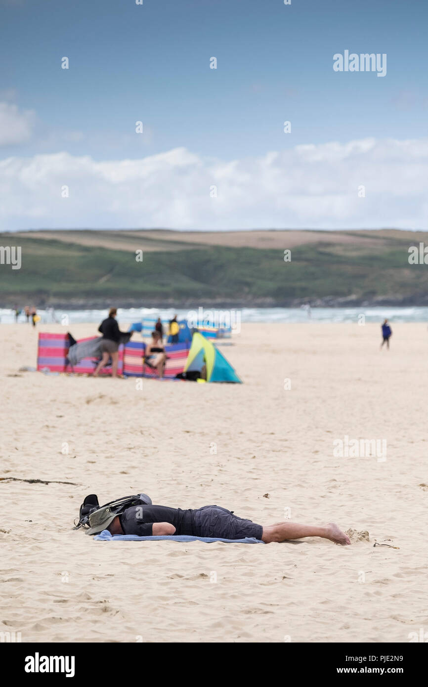 Un vacanziere sdraiato a faccia in giù sul Crantock Beach in Newquay Cornwall. Foto Stock