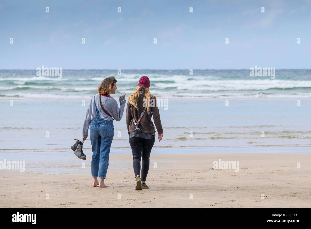 Due amici a piedi e chattare su Crantock Beach in Newquay Cornwall. Foto Stock