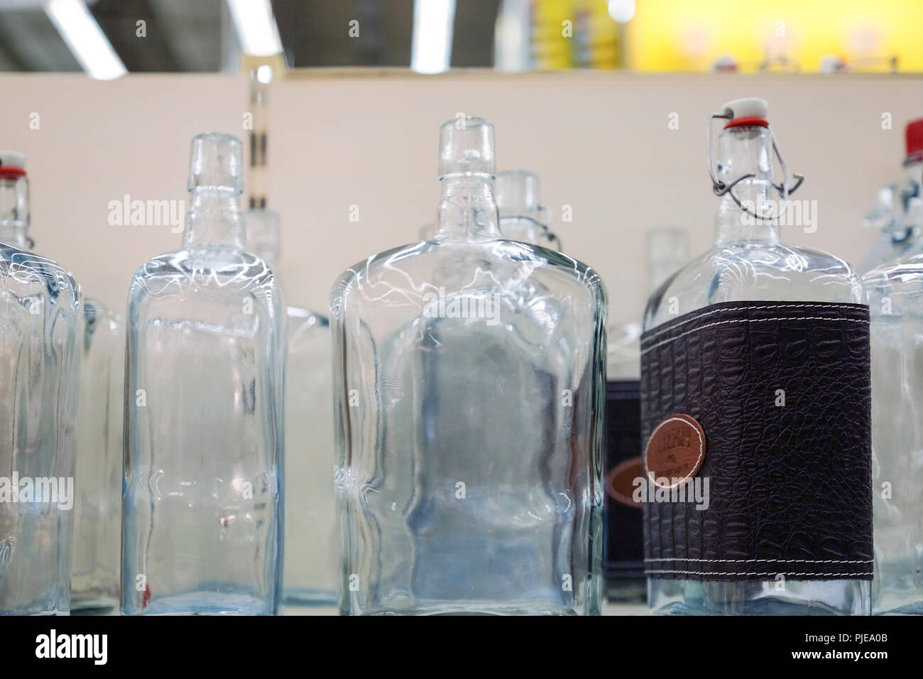 Svuotare le bottiglie di vetro in fabbrica per essere riempito di bevanda. Luce posteriore è lo sfondo Foto Stock
