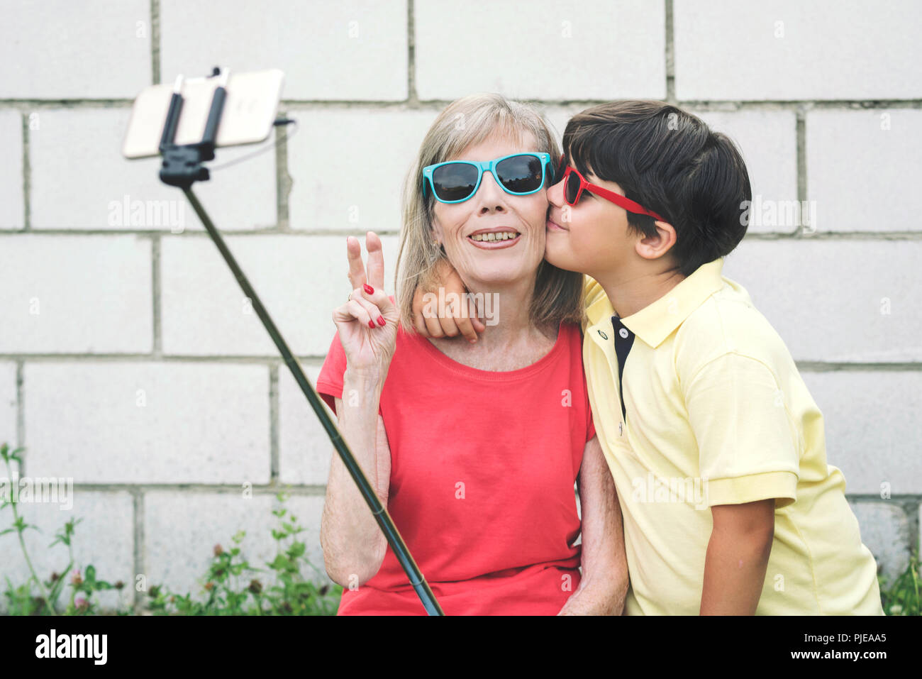 Funny Nonna e nipote con occhiali da sole prendendo selfie utilizza lo smartphone Foto Stock
