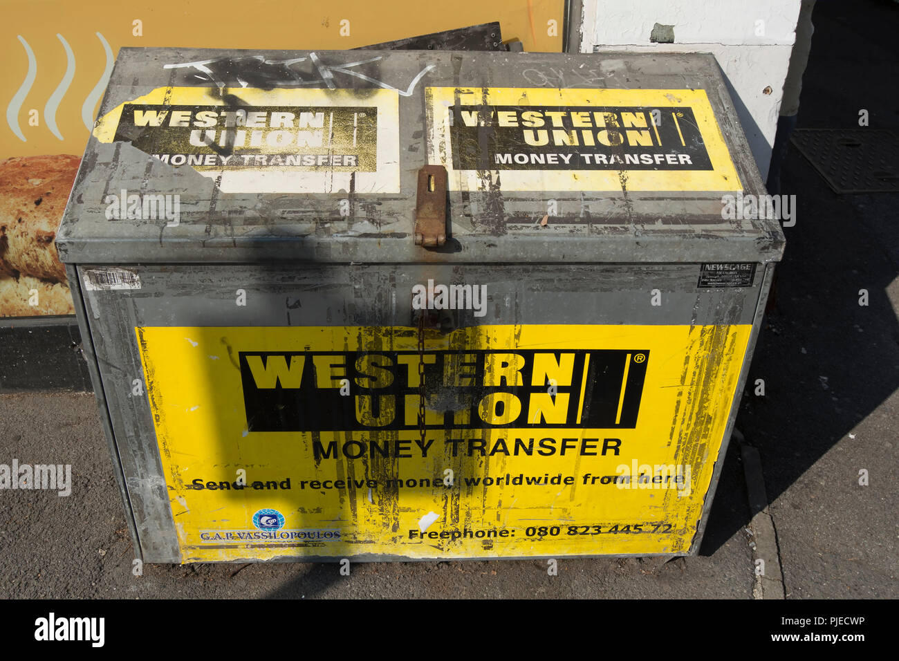 Trasferimento di denaro di Western Union annunci su una edicola al di fuori della scatola di archiviazione a Surbiton Surrey, Inghilterra Foto Stock