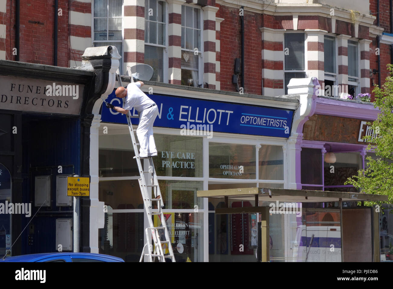 Pittore facendo un lavoro di manutenzione a Bexhill-on-Sea, Regno Unito Foto Stock