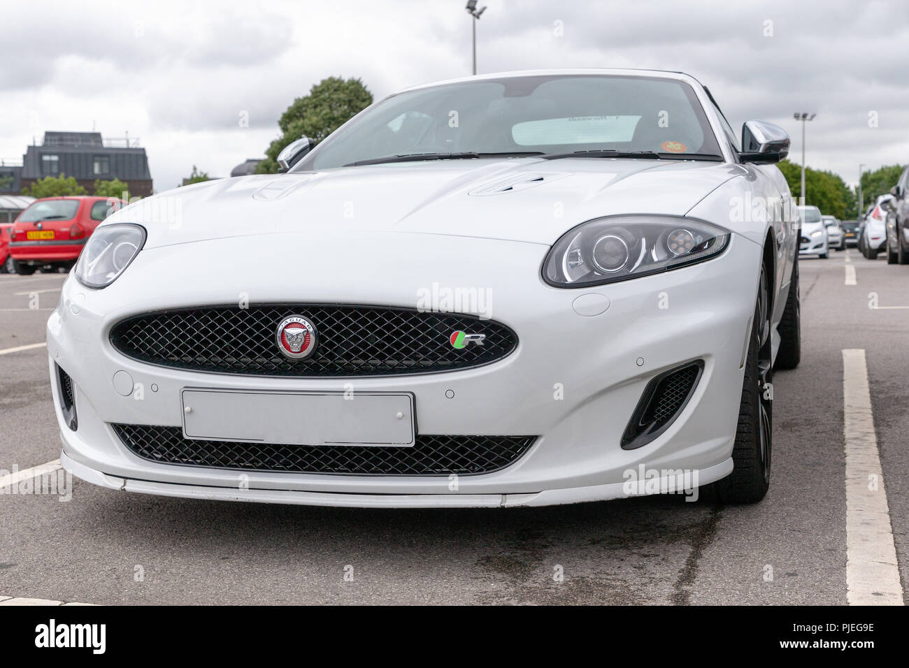 White Jaguar XK "R" in un supermercato parcheggio auto Foto Stock