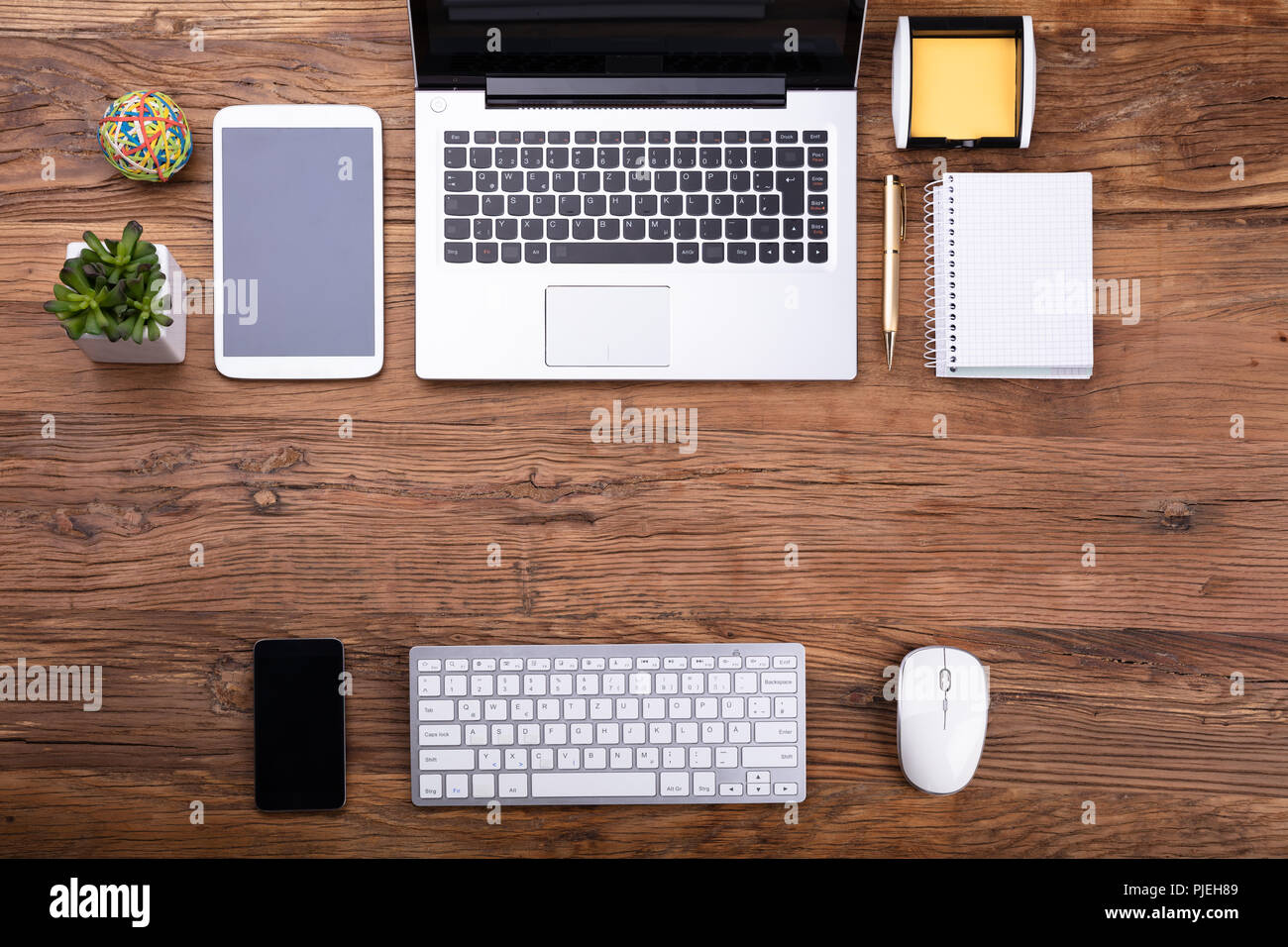 Vista aerea di forniture per ufficio e gadget elettronici sulla scrivania in legno Foto Stock