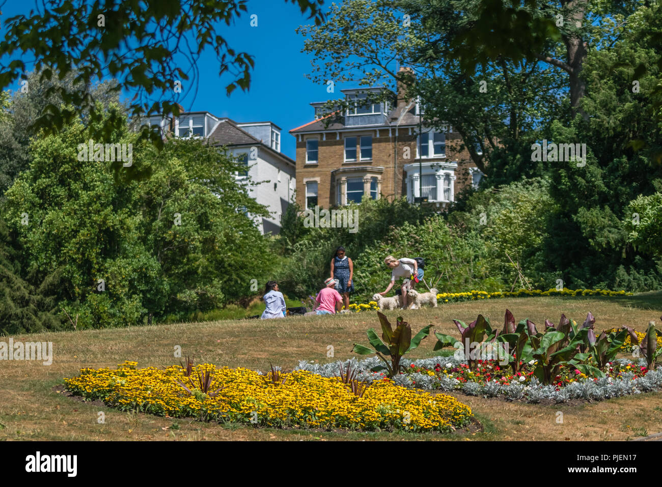 Londra, Inghilterra - Luglio 2018 : gruppo di persone sedute sull'erba nei giardini a terrazza vicino al Richmond Park Foto Stock