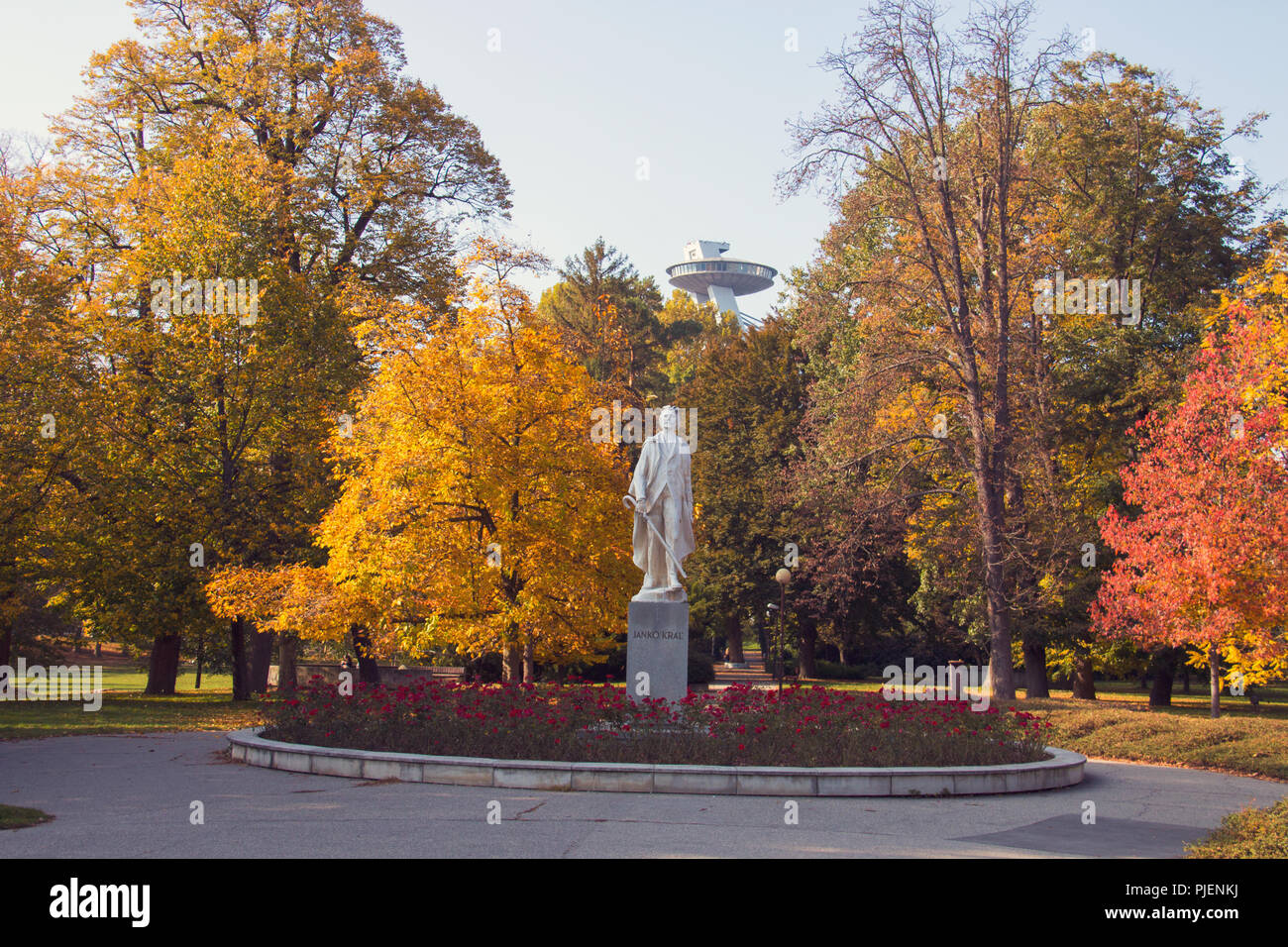 Il Janko Kral il parco della città di Bratislava, foglie di autunno su enormi alberi e la statua del poeta nel centro Foto Stock