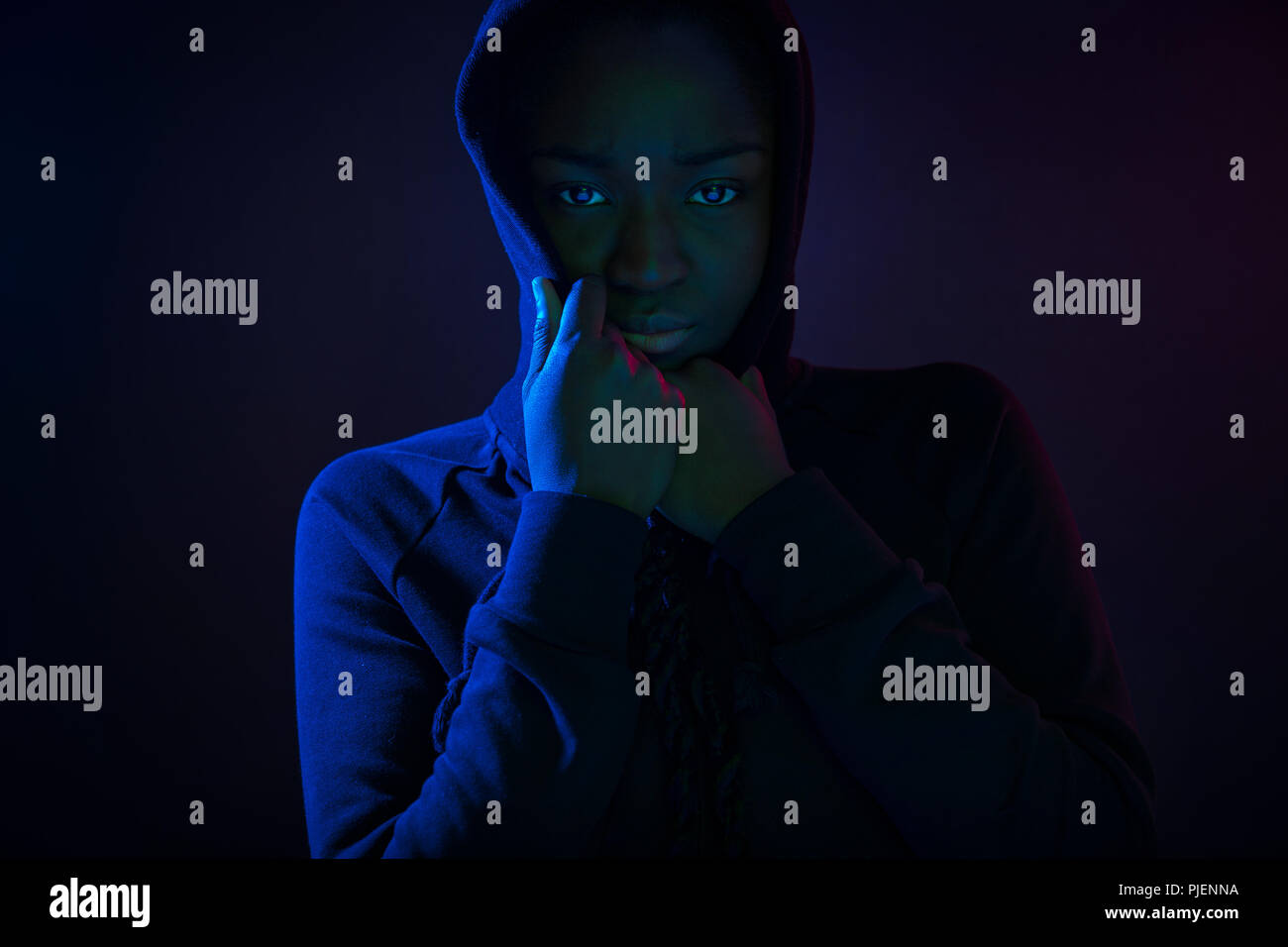 Ritratto colorato di un fresco donna con la pelle scura che indossa felpa con cappuccio Foto Stock