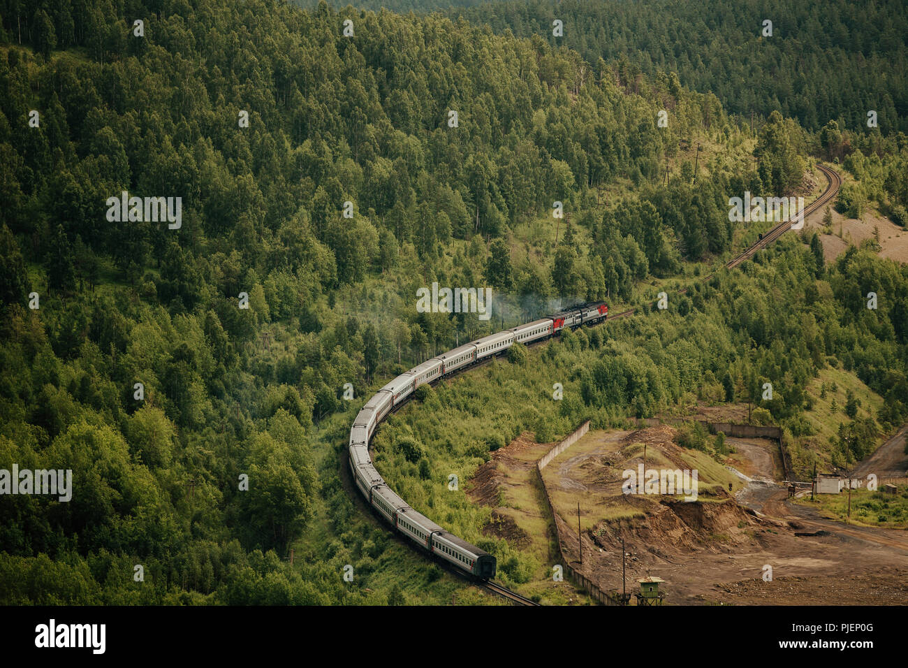 Treni passeggeri con locomotiva diesel passeggiate a piedi della montagna con la foresta verde Foto Stock