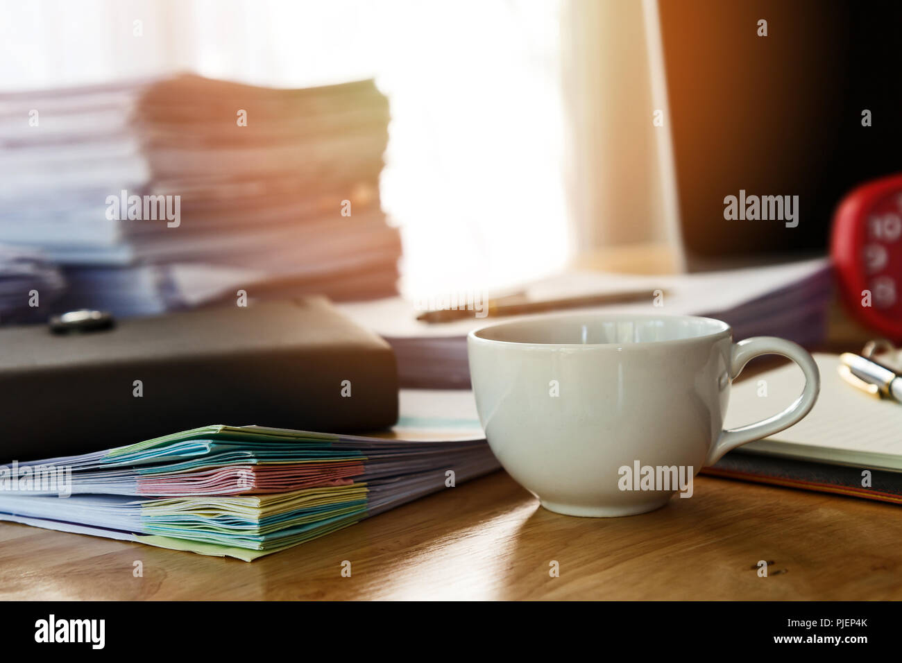 In prossimità di una tazza di caffè e delle forniture di ufficio sulla  scrivania in ufficio al mattino, tono caldo Foto stock - Alamy