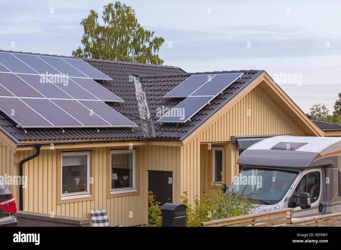 Pannelli solari sulla parte superiore delle tegole del tetto su tipici svedesi o legno scandinavo casa del pannello Foto Stock