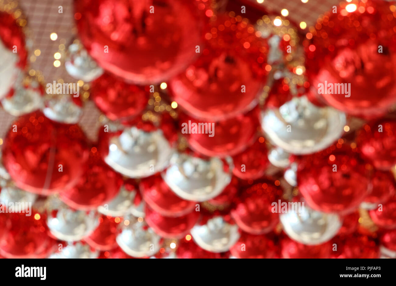 Abstract foto sfocata del soffitto riempita con rosso lucido e argento a forma di sfera ornamenti per lo sfondo o banner Foto Stock