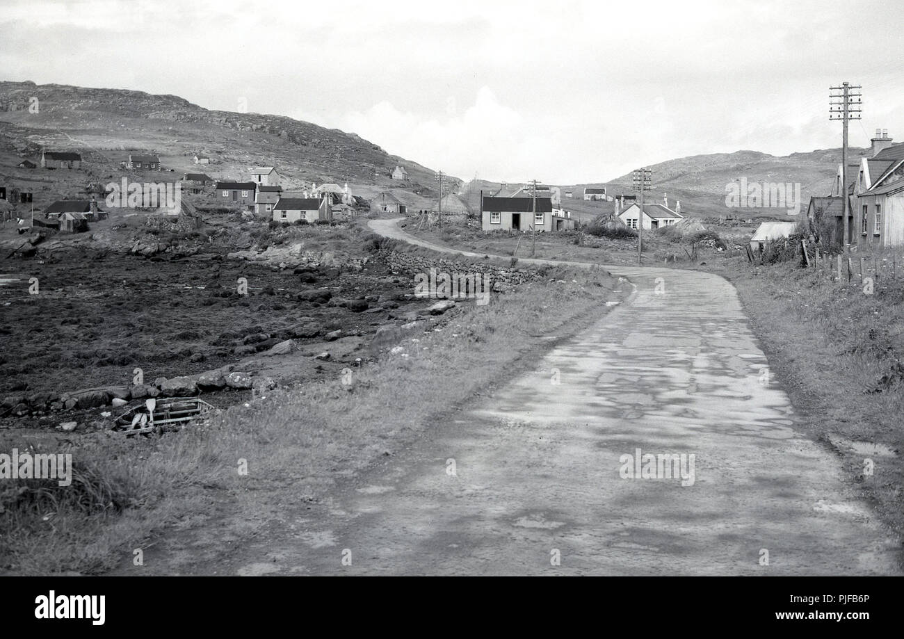 Degli anni Cinquanta, foto storiche che mostra un piccolo telecomando insediamento rurale nelle Ebridi Esterne, Western Isles, Scozia, con un narow strada vuota e un paio di singoli piani cottage crofters. Foto Stock