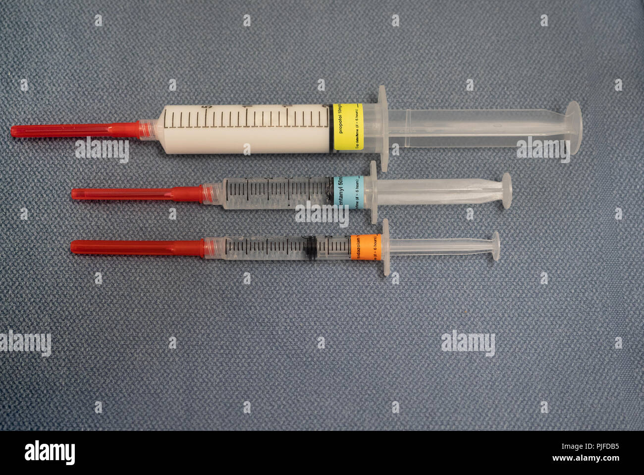Tre marcato farmaci anestesia, propofol, fentanil e midazolam, su un grigio blu asciugamano da sopra. Foto Stock