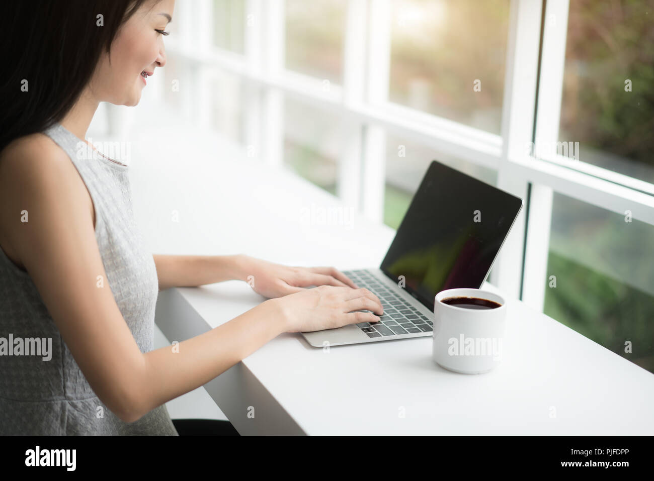Donna che utilizza un computer portatile durante una pausa caffè, mani vicino fino Foto Stock