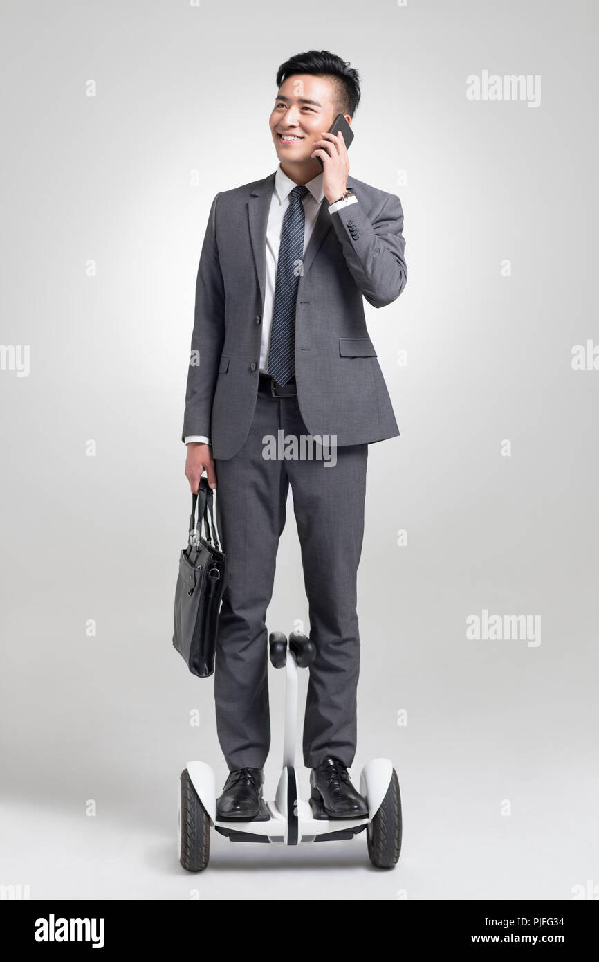 Fiducioso giovane imprenditore segway equitazione Foto Stock
