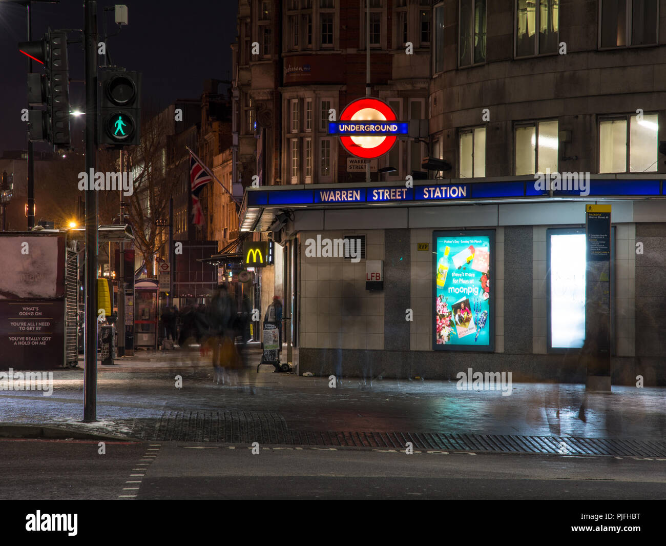London, England, Regno Unito - 27 Febbraio 2018: pedoni a piedi lungo Tottenham Court Road al di fuori di Warren Street Stazione della metropolitana di Londra di notte. Foto Stock