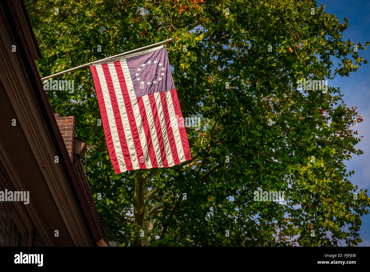 La bandiera statunitense a cui si fa comunemente riferimento come la Betsy Ross bandiera come visto dalla strada che pende da una costruzione a Philadelphia, PA. Foto Stock