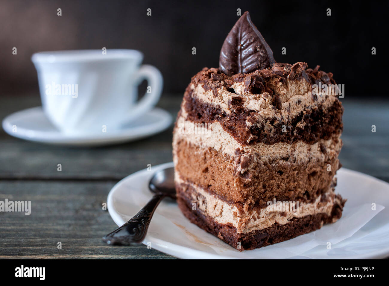 Gustoso pezzo di torta al cioccolato su un tavolo di legno sfondo Foto Stock