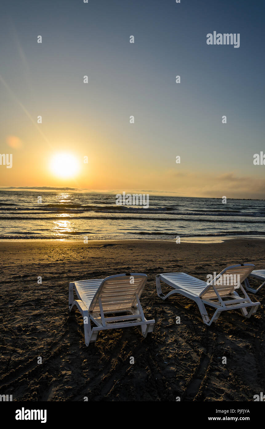 I lettini sulla spiaggia del Mar Nero all'alba, la calda atmosfera del sole. Foto Stock