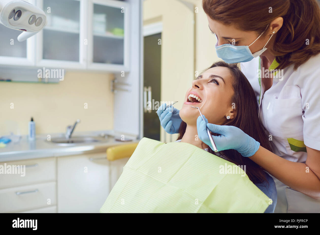 Una ragazza con un bel sorriso con un dentista. Foto Stock