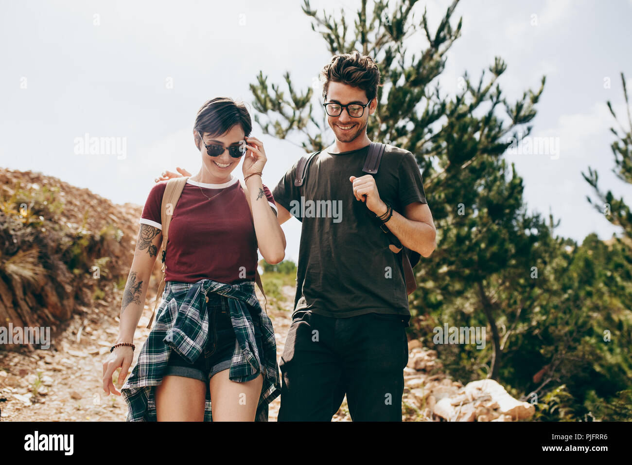Escursionismo coppia in una località di campagna. L uomo e la donna trekking attraverso una foresta di indossare zaini. Foto Stock